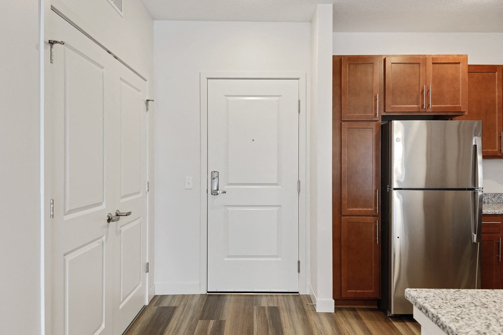 a kitchen with white doors and a stainless steel refrigerator