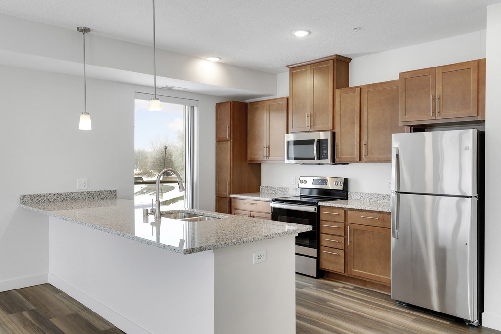 a kitchen with a granite counter top and a stainless steel refrigerator