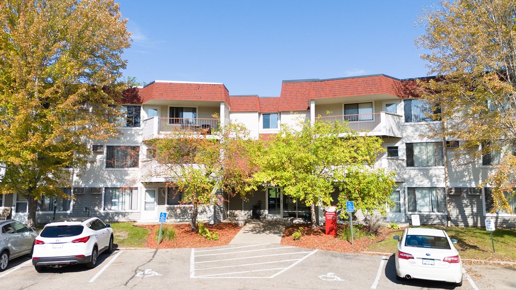 an apartment building with cars parked in front of it