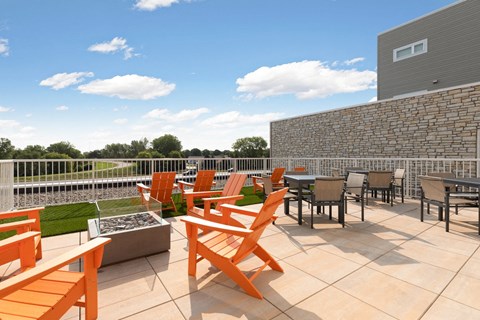 a patio with tables and chairs and a fire pit