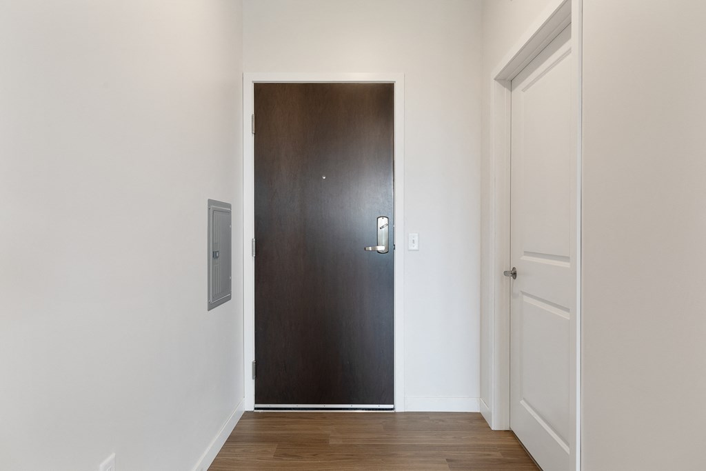 a wooden door in a room with white walls and a wooden floor
