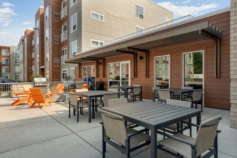a patio with tables and chairs outside of a building