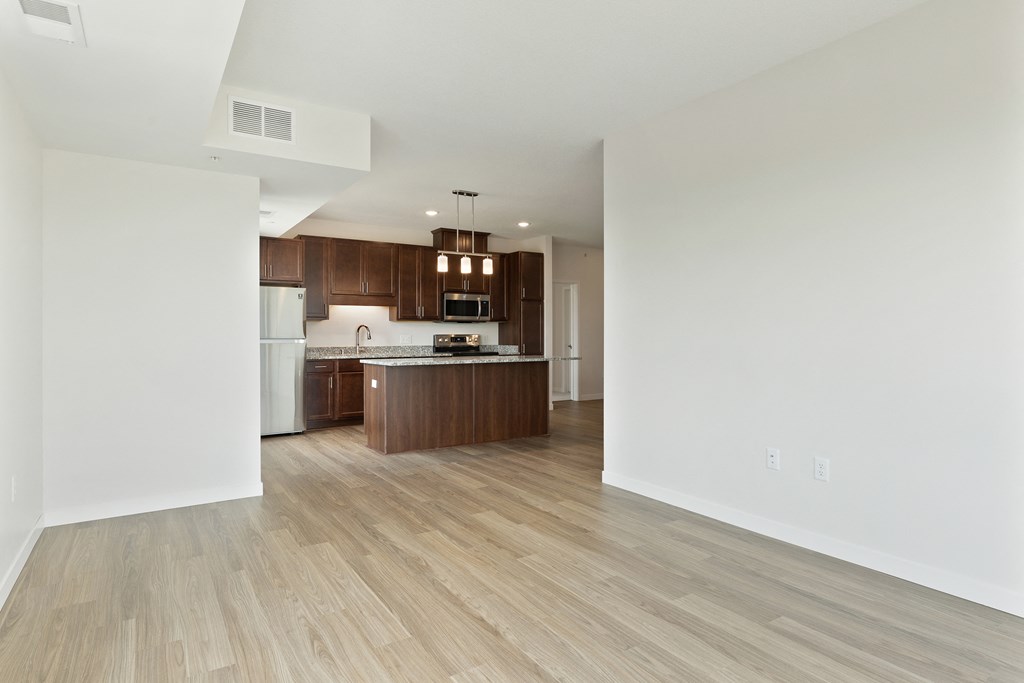 A kitchen with wooden floors and white walls at Sonder Point 50+ Apartments, Brooklyn Center