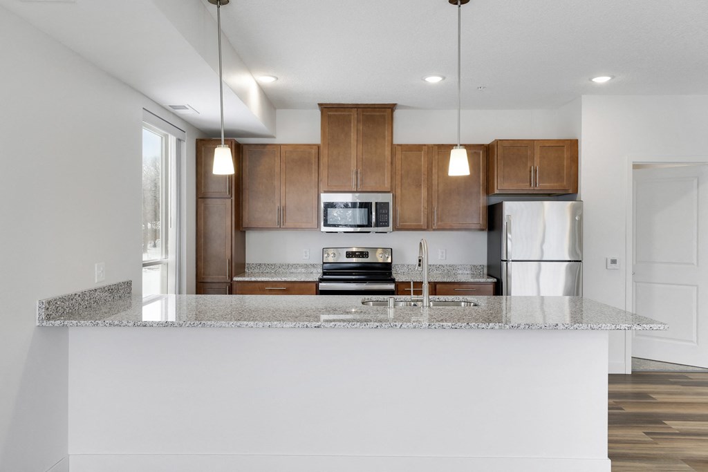 a kitchen with a granite counter top and wooden cabinets