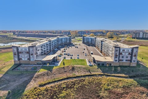 A large building complex with a parking lot in front.