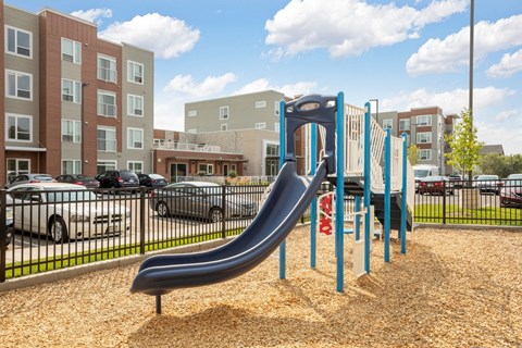 a playground with a slide at an apartment complex