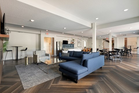 a living room with couches and chairs and a kitchen with a table and chairs
