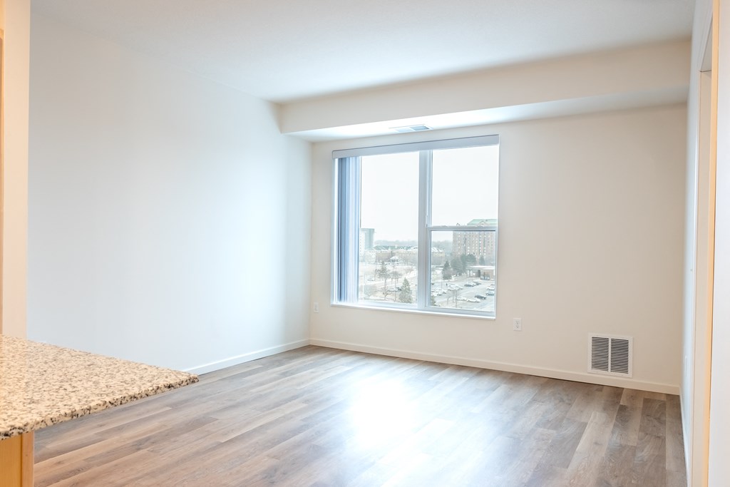a living room with a large window and wood flooring