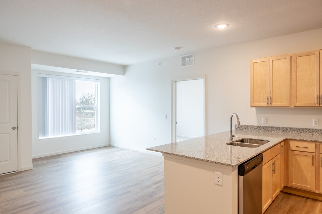 an empty kitchen and living room with a large window