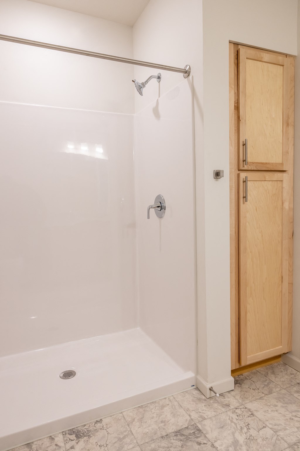a white shower in a bathroom with a wooden door