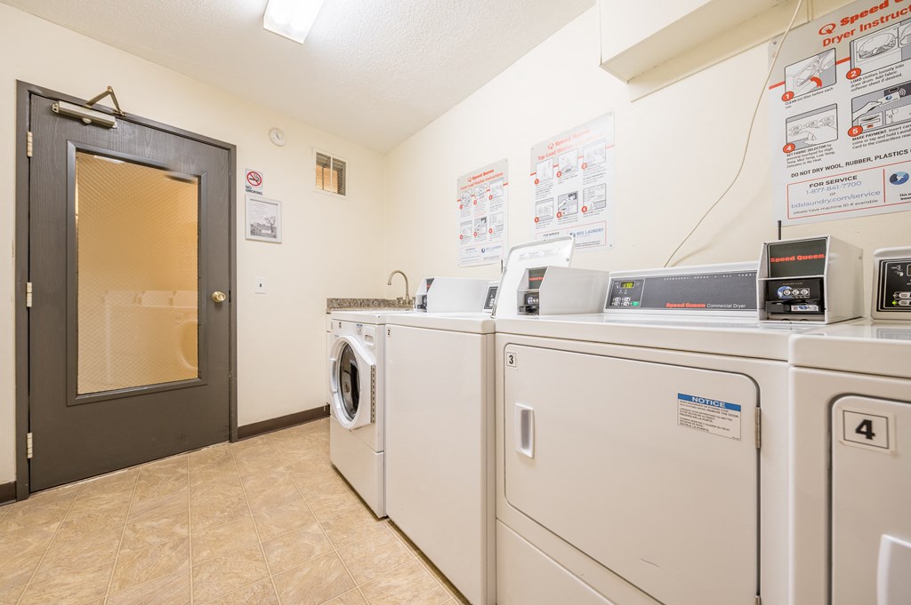 a laundry room with washers and dryers