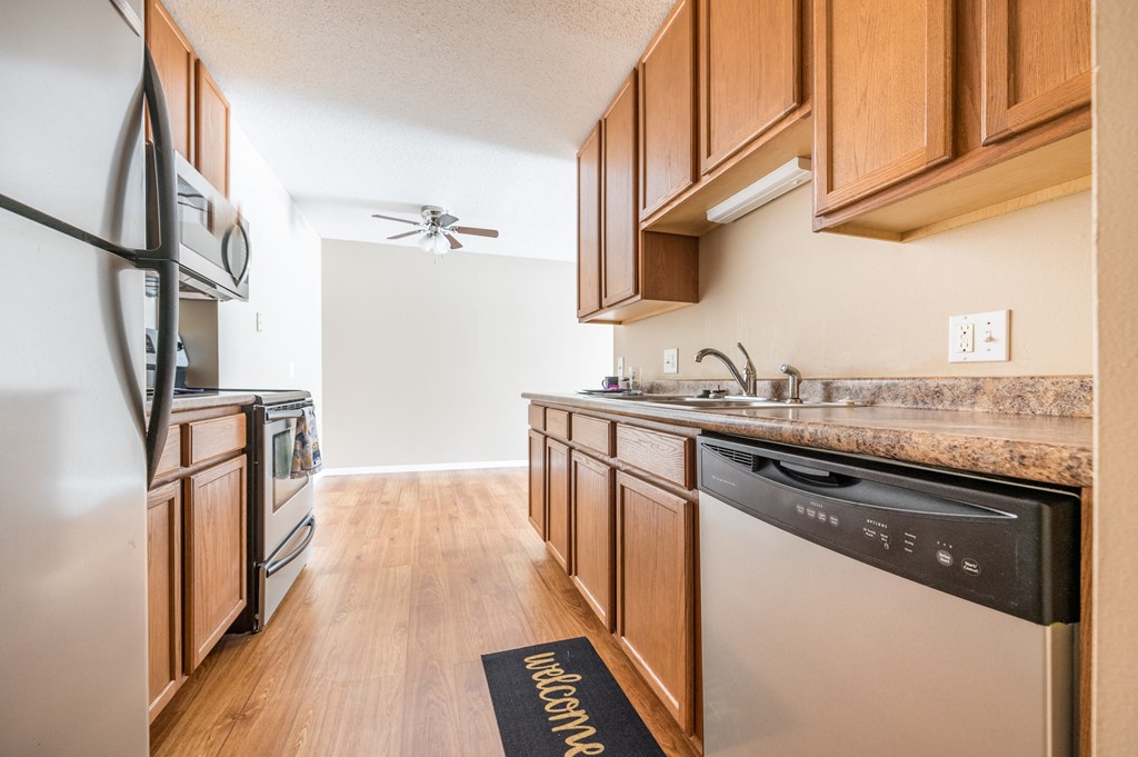 a kitchen with wooden cabinets and stainless steel appliances
