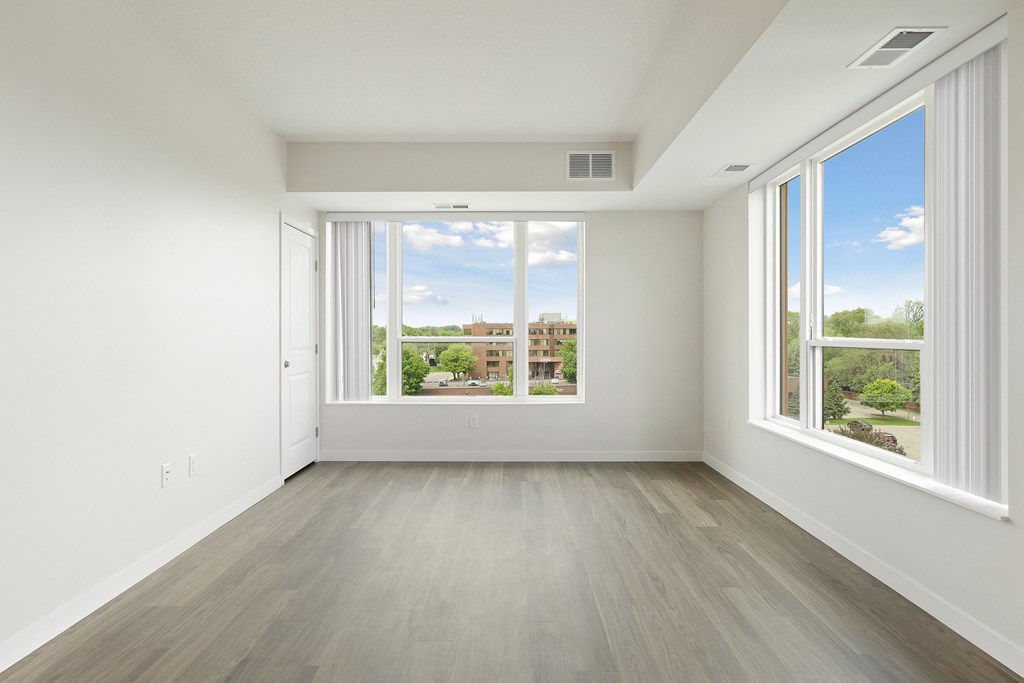 A large empty room with a view of the outside through the windows at Sonder Point 50+ Apartments, Brooklyn Center, 55430