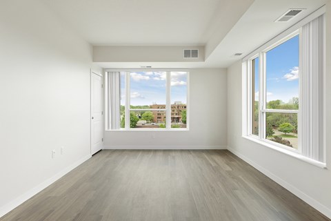 A large empty room with a view of the outside through the windows at Sonder Point 50+ Apartments, Brooklyn Center, 55430
