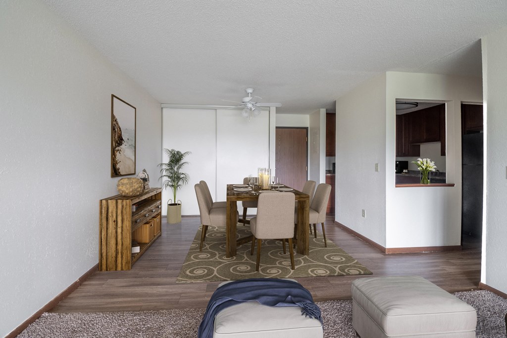 a dining room and living room with white walls and wood floors