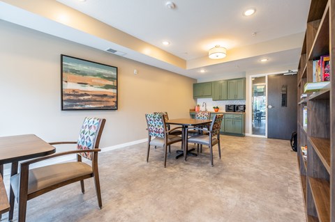 a dining area with a table and chairs and a kitchen in the background at Sonder Point 50+ Apartments, Minnesota, 55430