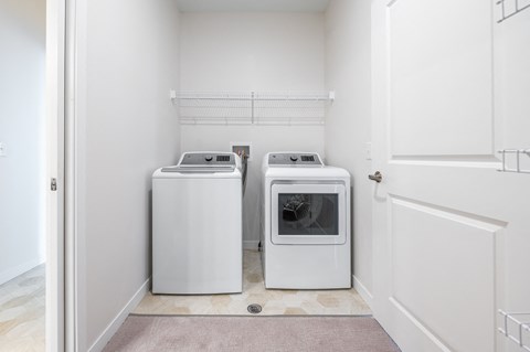 a washer and dryer in a laundry room at Sonder Point 50+ Apartments, Minnesota