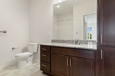 A white toilet sits next to a sink in a bathroom at Sonder Point 50+ Apartments, Brooklyn Center, Minnesota