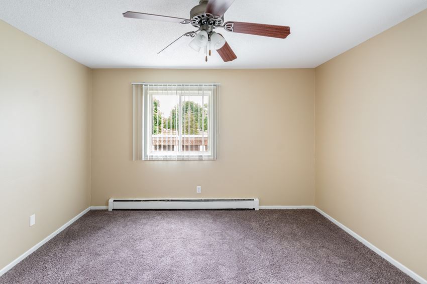 an empty room with a ceiling fan and a window - Photo Gallery