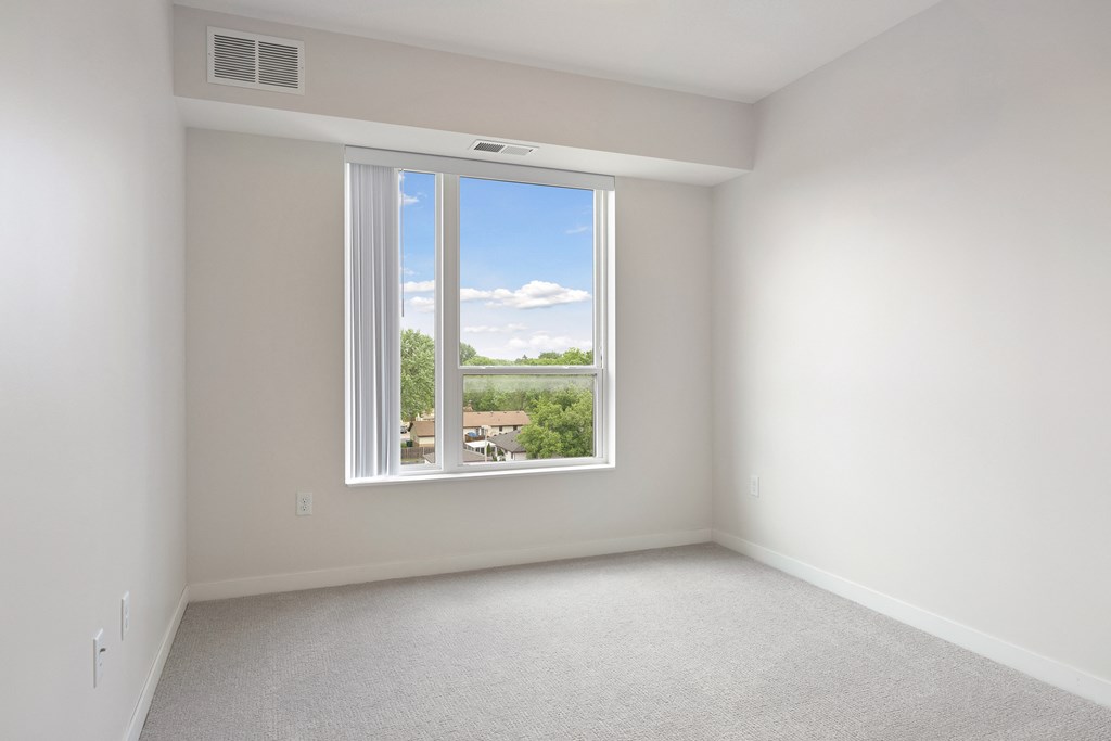 A room with a window overlooking a residential area at Sonder Point 50+ Apartments, Brooklyn Center, MN
