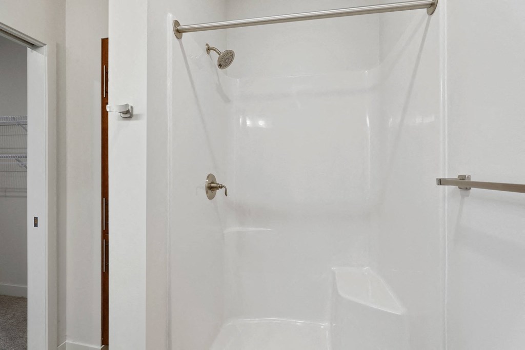 a white shower in a bathroom with a shower curtain