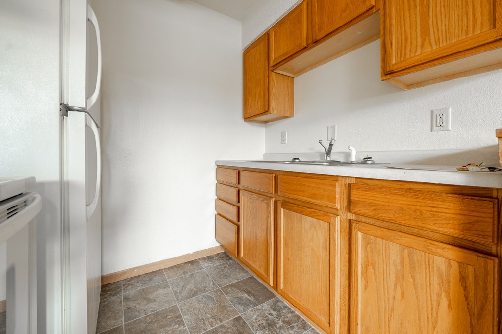 a kitchen with white appliances and wooden cabinets