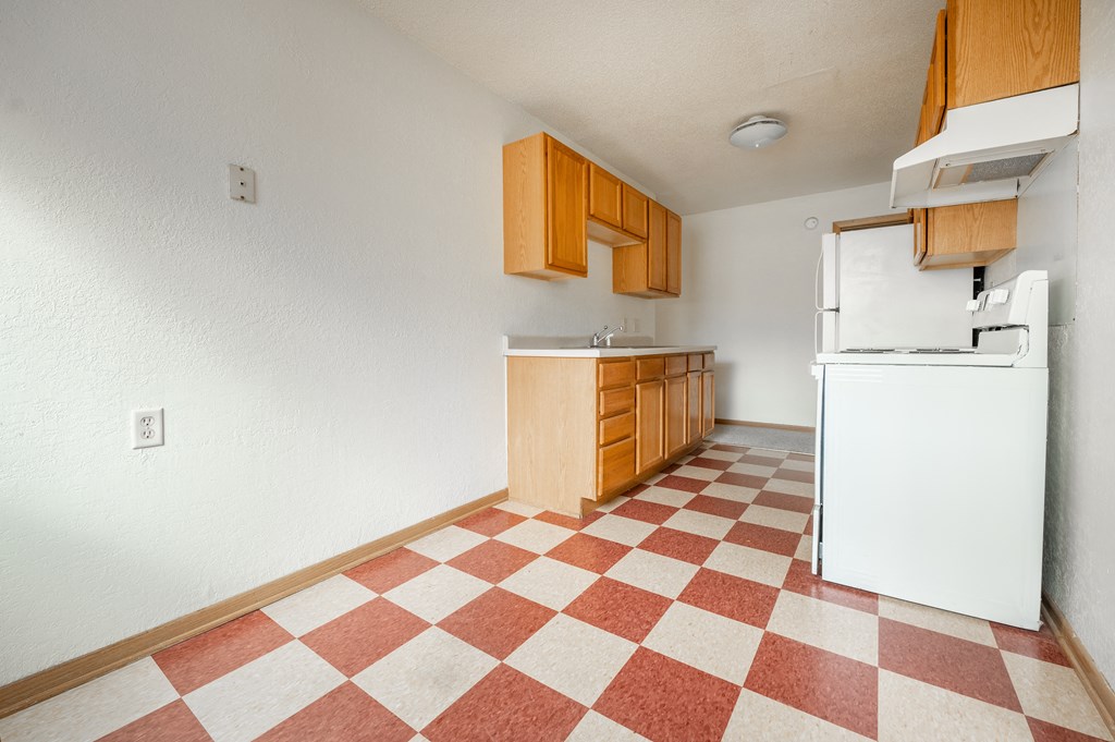 a kitchen with a white refrigerator freezer next to a stove top oven