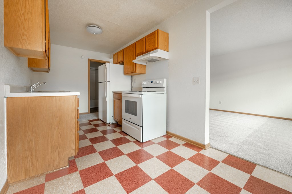 a kitchen with a white refrigerator freezer next to a stove top oven
