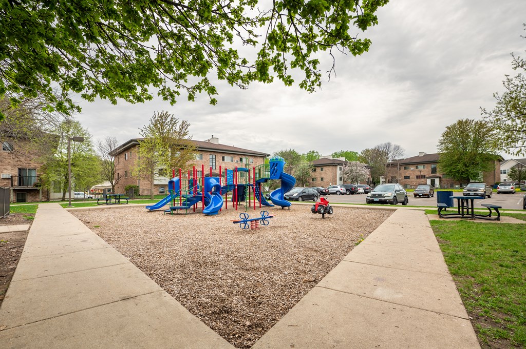 a playground with slides and monkey bars in front of a building