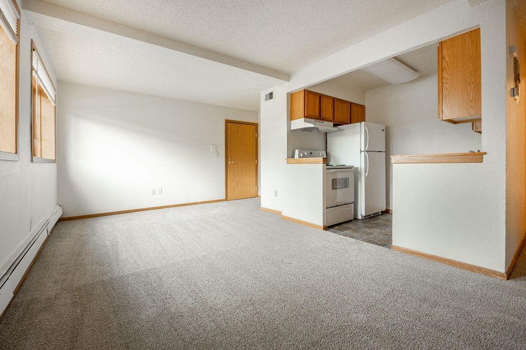 an empty living room with a kitchen in the corner at Ames Lake Neighborhood Apartments, St. Paul, MN, 55106