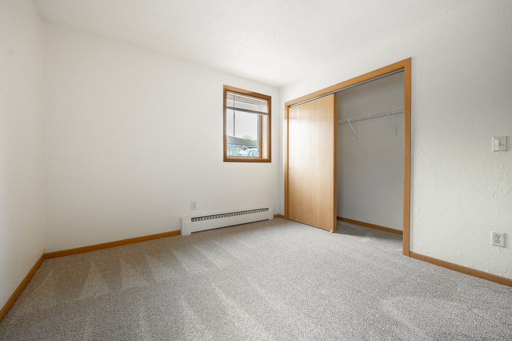 an empty room with a closet and a window at Ames Lake Neighborhood Apartments, St. Paul, 55106