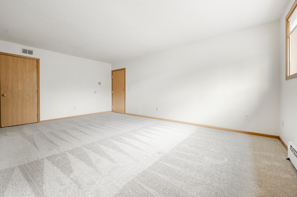 the living room of a house with a white floor and a wooden door at Ames Lake Neighborhood Apartments, St. Paul, 55106