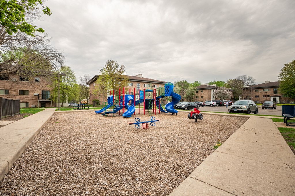 a playground in a park in front of a building at Ames Lake Neighborhood Apartments, Minnesota