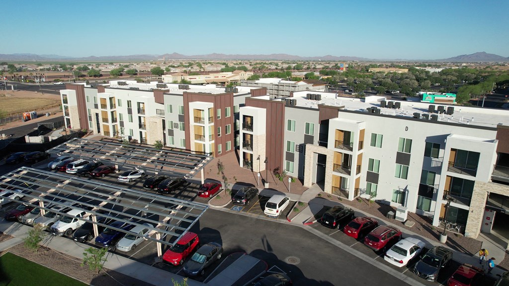 an aerial view of a large apartment complex with a parking lot and cars in the lot