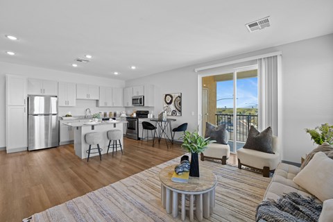 A modern kitchen with white cabinets and a dining area with a table and chairs.