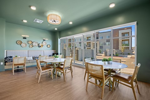 A dining room with a table set for four and a view of a building outside the window at Copa Flats Apartments, Maricopa, Arizona