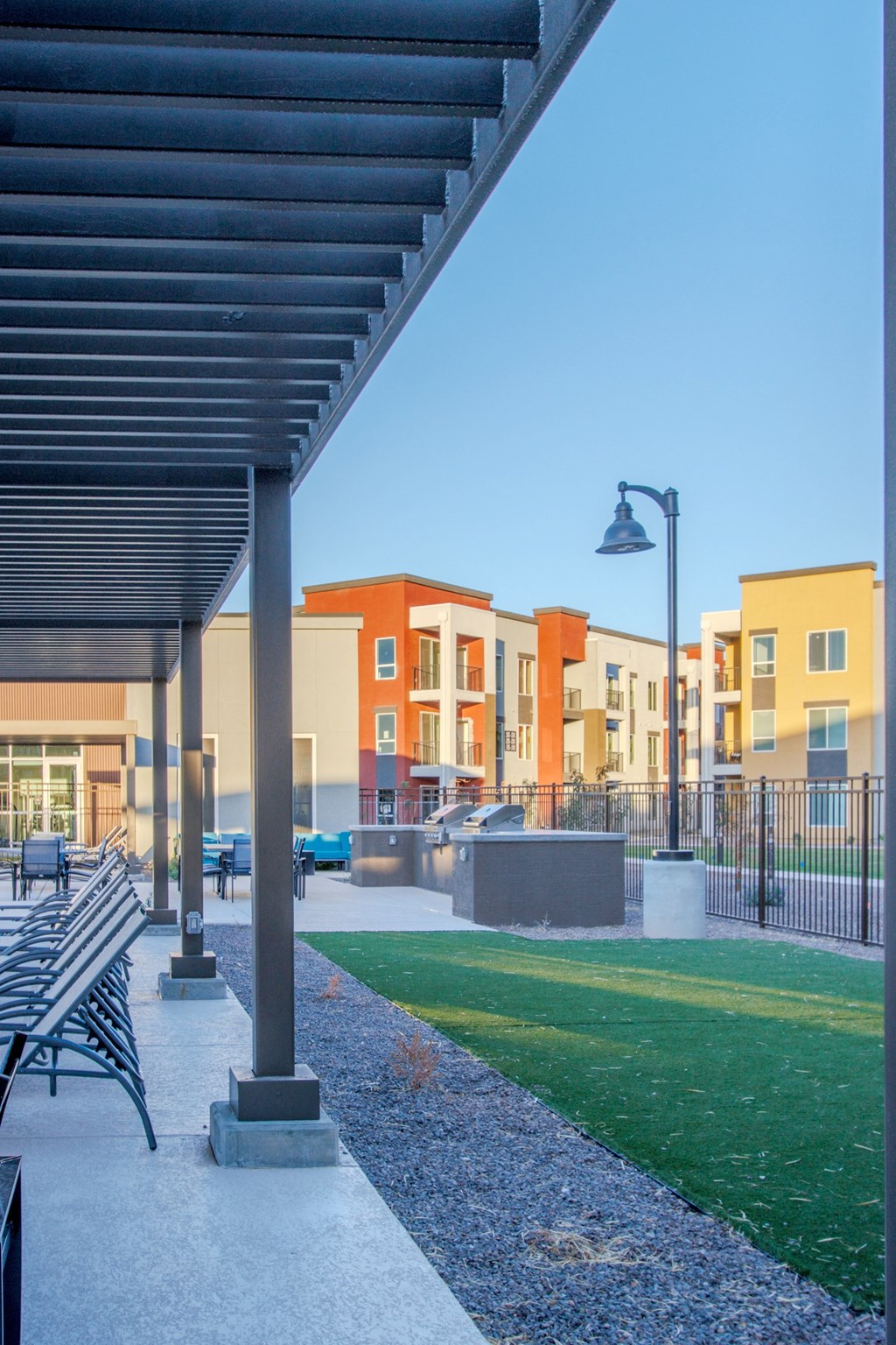 a park with benches and a lawn in front of some apartments