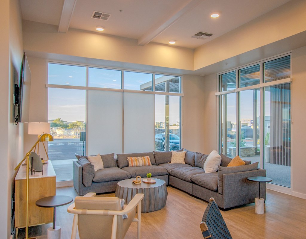 a living room with couches and a coffee table and large windows at Copa Flats, Maricopa, AZ