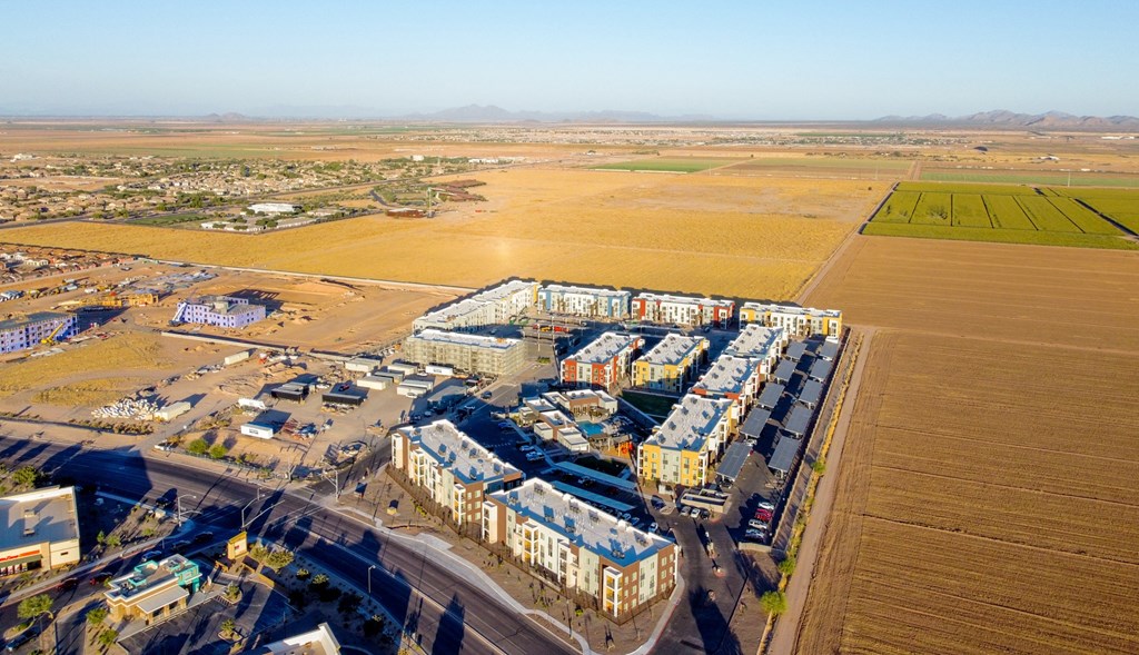 an aerial view of a city with buildings and a field at Copa Flats, Maricopa, AZ