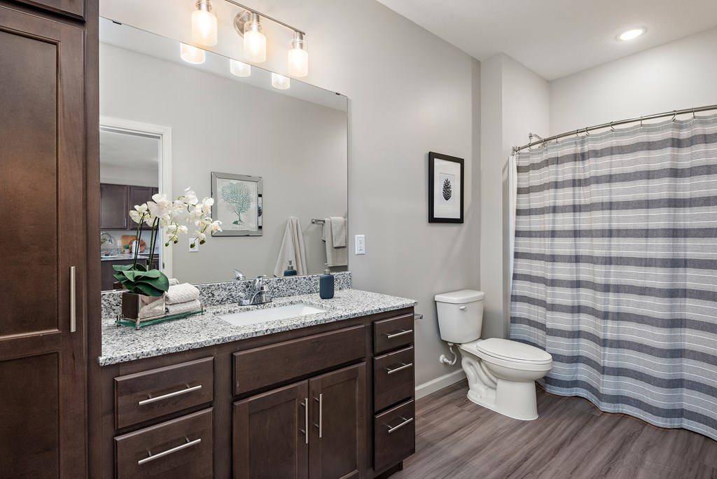 A bathroom with a toilet, sink, and shower.