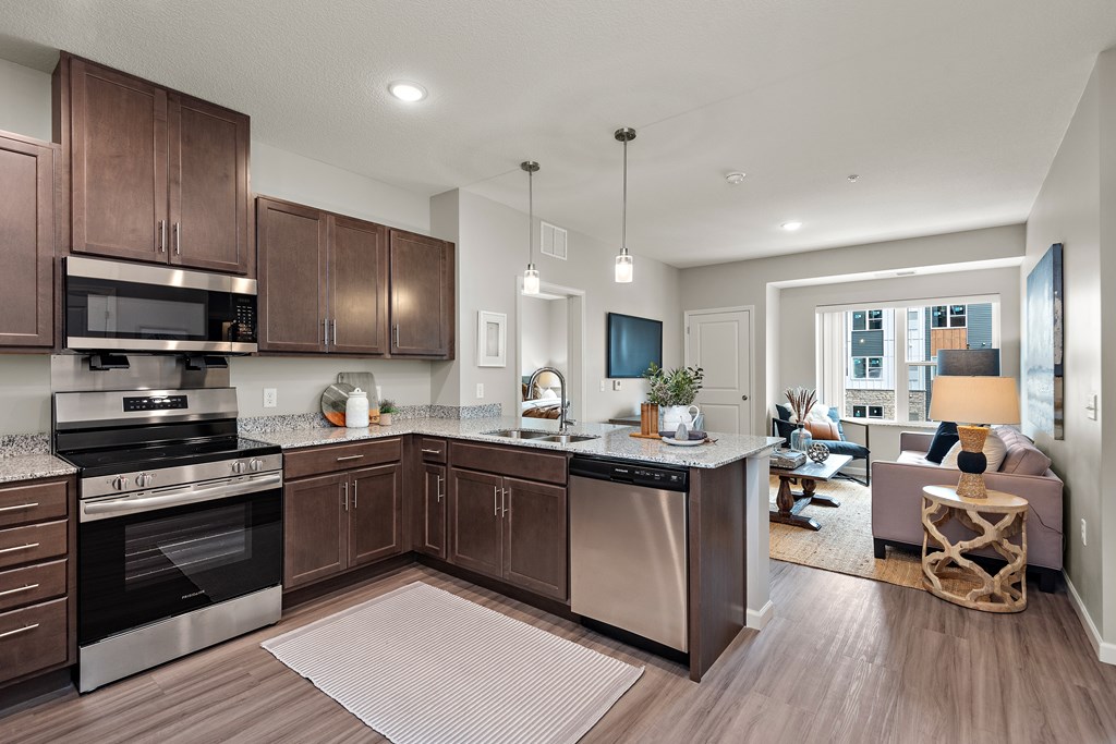 A modern kitchen with dark wood cabinets and stainless steel appliances.