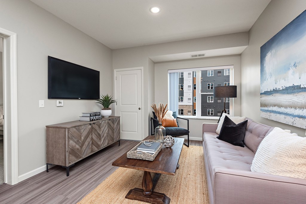 A living room with a couch, a coffee table, and a large painting on the wall.