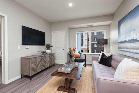 A living room with a couch, a coffee table, and a large painting on the wall.