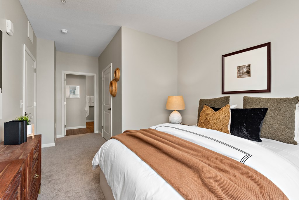 A bedroom with a large bed and a brown blanket.