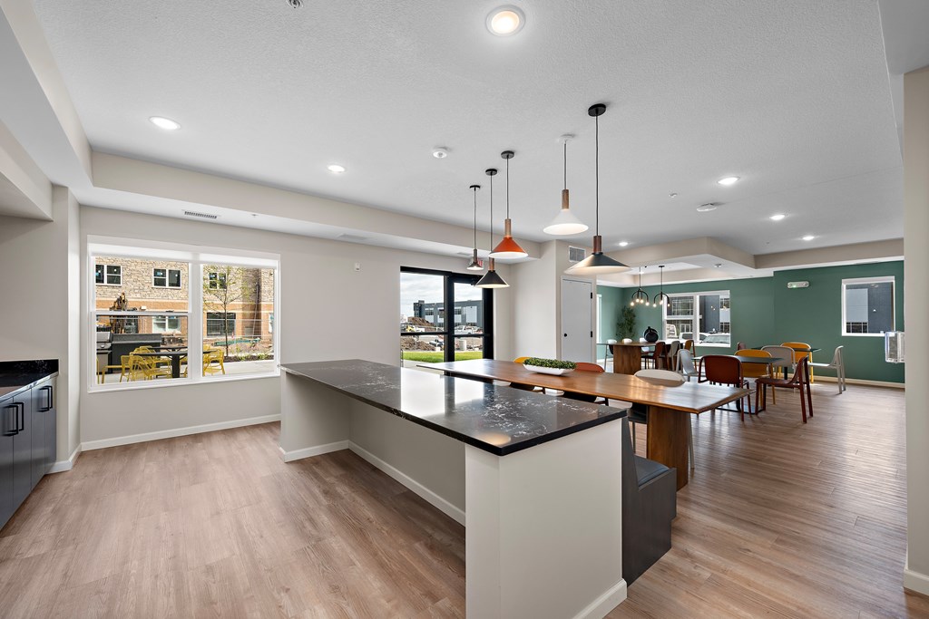 A modern kitchen with a large island and pendant lights.