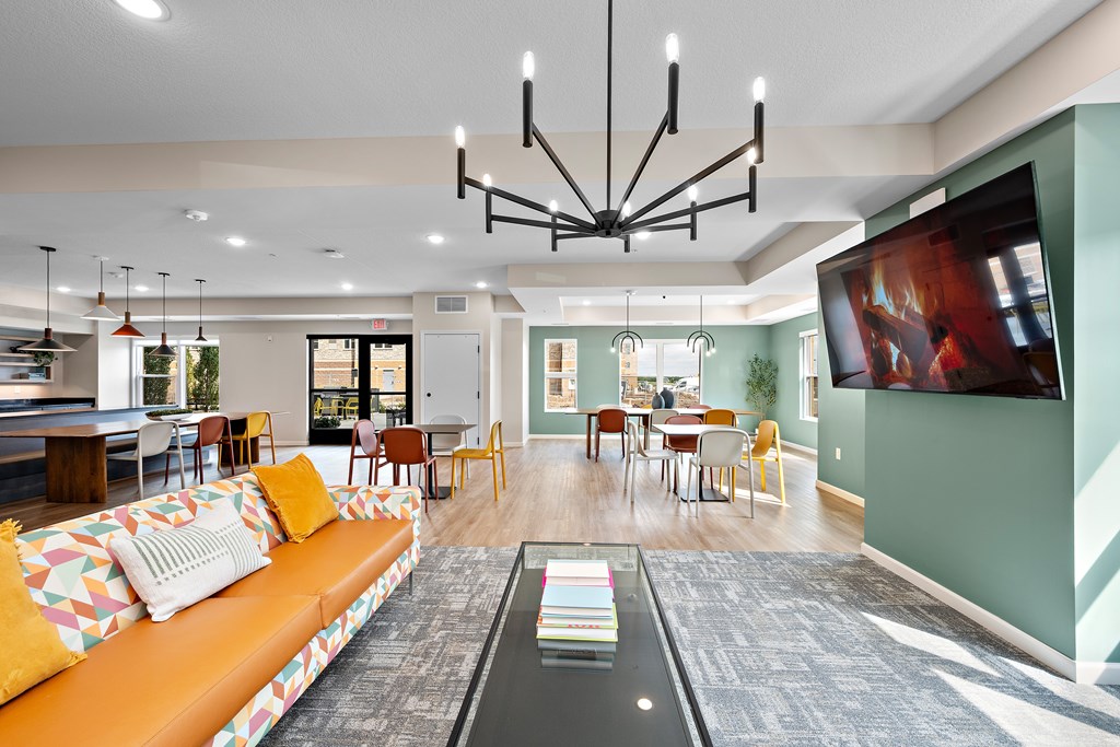 A living room with a couch, chairs, and a television.