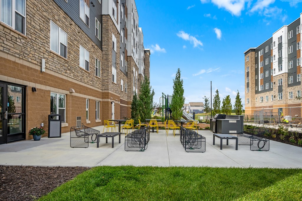 A sunny day at a courtyard with a playground and a building in the background.