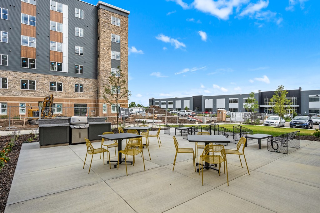 A sunny day at a modern outdoor seating area with tables and chairs.