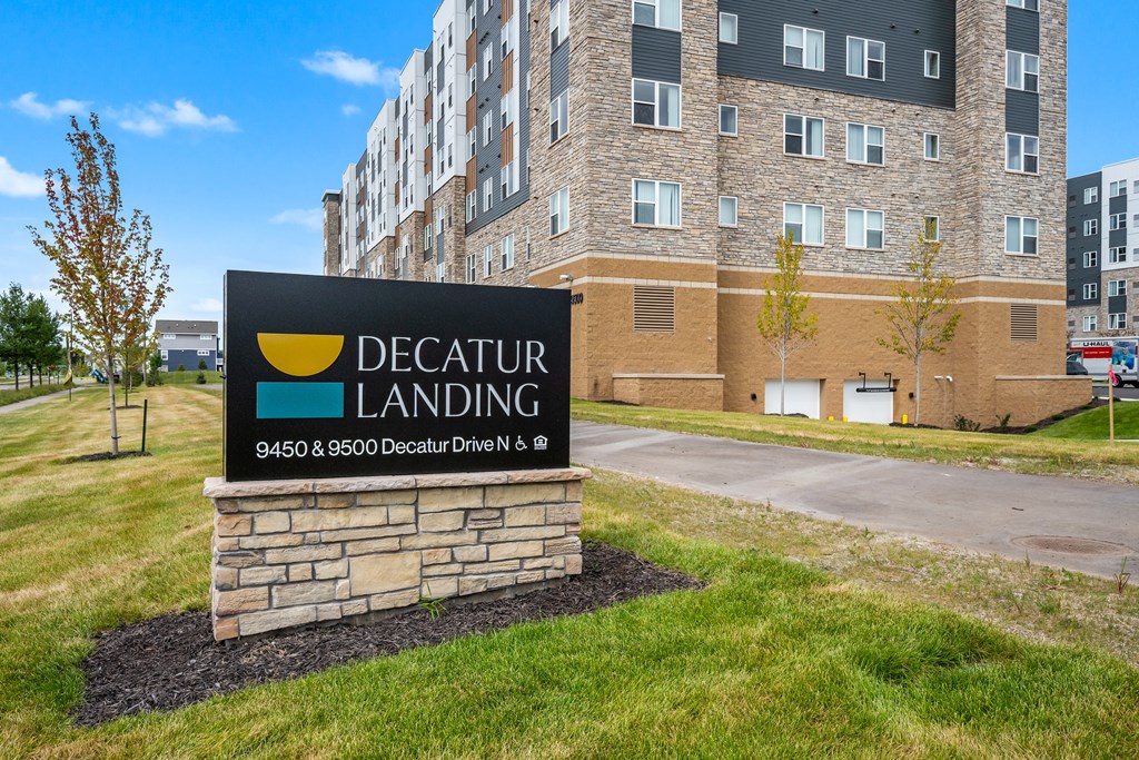 A sign for Decatur Landing in front of a building.