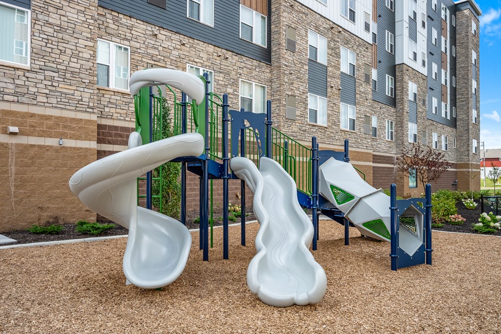 A playground with a slide and a climbing frame.